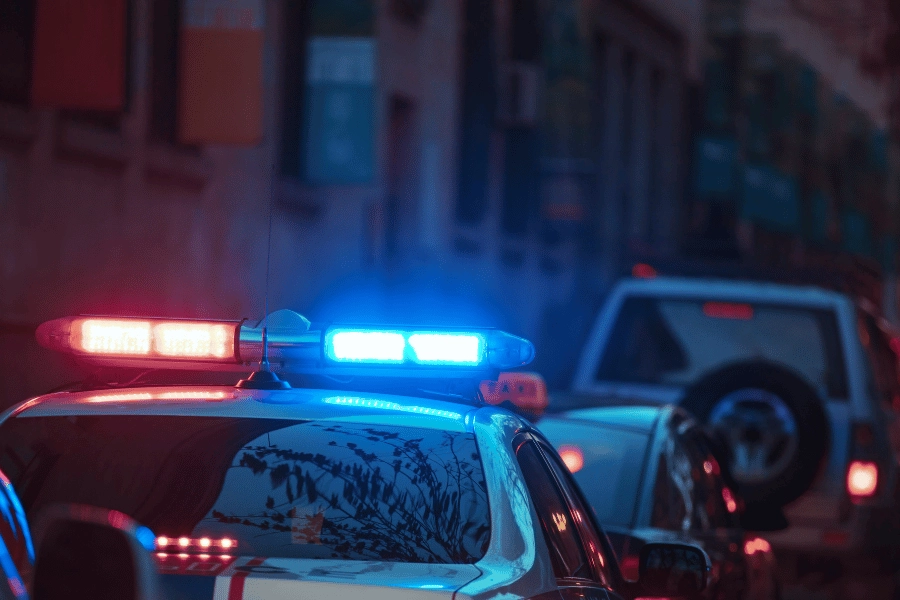 police car parked at night with red and blue lights flashing